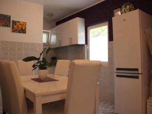 a kitchen with a table and a white refrigerator at Villa Nika-Five Bedroom Villa with Pool in Mlini +2 photos