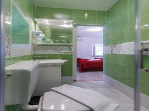 ein grünes Bad mit einem WC und einem Waschbecken in der Unterkunft Villa Balarin - Five Bedroom Holiday Home with Terrace and City View in Bol + 25 Fotos