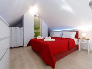 ein Schlafzimmer mit einem roten Bett mit einer roten Decke in der Unterkunft Villa Balarin - Five Bedroom Holiday Home with Terrace and City View in Bol