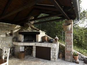 un horno de piedra al aire libre con techo de madera en Villa Dol-Three Bedroom Villa with Pool, en Postira