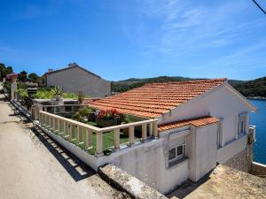 a house with a balcony next to the water at Apartment OM - One Bedroom Apartment with Balcony and Sea view in Povlja +16 photos