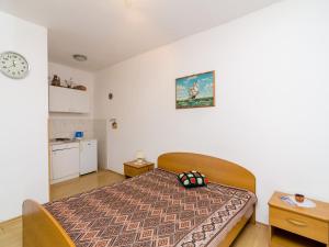 a bedroom with a bed and a clock on the wall at Apartments Ra ica Molunat - Basic Studio in Molunat +8 photos