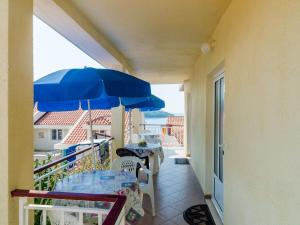 a balcony with tables and a blue umbrella at Apartments Ra ica Molunat - Basic Studio in Molunat