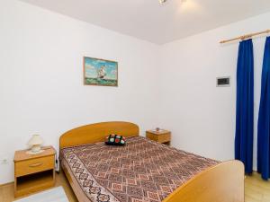 a bedroom with a bed and blue curtains at Apartments Ra ica Molunat - Basic Studio in Molunat