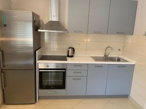 a kitchen with a stainless steel refrigerator and a sink at Apartments Nives - Three Bedroom Apartment with Terrace and Sea View in Smokvica