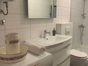 a white bathroom with a sink and a toilet at Apartments Nives - Three Bedroom Apartment with Terrace and Sea View in Smokvica