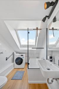 a bathroom with a sink and a washing machine at BackHome - BUSINESS&FAMILY - Parken, 3-Zimmer, SmartTV, Balkon, Waschmaschine, ruhige Stadtrand-Lage, Netflix, 60qm, 24h Checkin in Ludwigsburg +16 photos