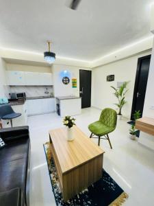 a living room with a table and a green chair at City view stay by Royal Rooms in Noida