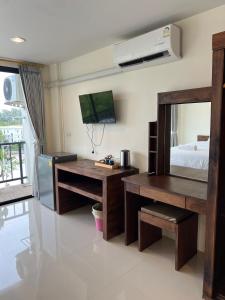 a room with a desk and a bed and a television at Rawai Sea Beach in Phuket +7 photos
