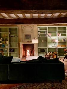 a living room with a fireplace and a couch at La Breteche du Perche in Saint-Germain-de-la-Coudre