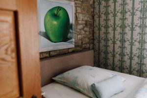 a picture of a green apple in a painting next to a bed at Hotel Altes Rittergut in Sehnde