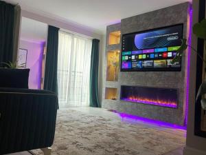 a living room with a fireplace and a tv at The Exclusive Jacuzzi Apartment in Birmingham