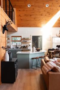a kitchen and living room with a couch and a table at Award-winning A-frame Chalet W Cedar Tub & Views in Julian +58 photos