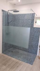 a shower with a glass door in a bathroom at Petit Chalet romantique en normandie in Le Pin-au-Haras