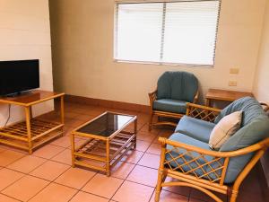 Una sala de estar con sillas y un televisor. en Koala Beach Resort Cairns, en Cairns