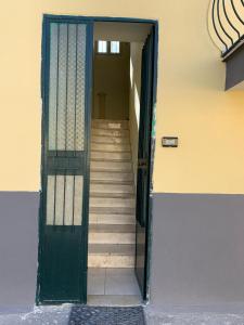 a green door with stairs leading into a building at Holiday Home in San Giorgio a Cremano