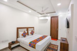 a bedroom with a bed and a television in it at FabHotel Aerosky - Nr Yashobhoomi Convention Centre in New Delhi