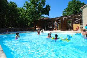 a group of children playing in a swimming pool at Résidence Lagrange Vacances Les Ségalières in Gramat