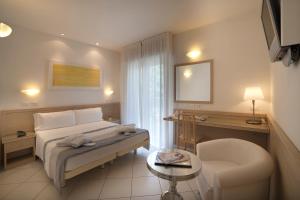 a hotel room with a bed and a chair at Hotel Gala in Riccione