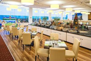 テンプリーンにあるAHORN Seehotel Templinのテーブルと椅子とビュッフェのあるレストラン