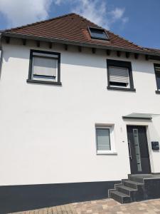 une maison blanche avec trois fenêtres dans l'établissement 55qm Messe Wohnung, Trade Fair, 6 Minuten zur Messe, à Rheinstetten