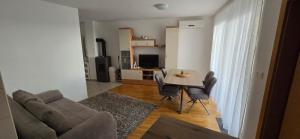 a living room with a couch and a table and chairs at Princess in Brodarica