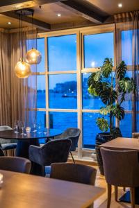a restaurant with tables and chairs and a large window at Villa Bryggekanten - by Classic Norway Hotels in Henningsvær