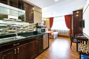 a kitchen with a sink and a living room at Collection O Emerald Luxury Apartment - Near SECC in Ho Chi Minh City
