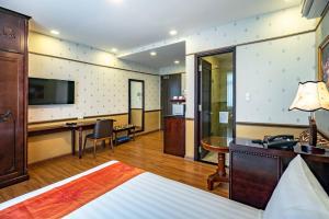 a hotel room with a bed and a desk at Collection O Emerald Luxury Apartment - Near SECC in Ho Chi Minh City