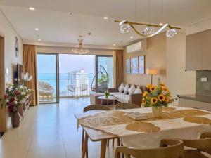 une cuisine et un salon avec une table et un canapé dans l'établissement The Sóng Apartment Vũng Tàu-RUBYVILLA, à Vung Tau