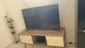 a flat screen tv sitting on top of a wooden stand at L'Emeraude in Saint-Pierre +13 photos