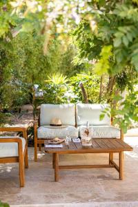 een bank en een salontafel op een patio bij Le clos de la pinède chambre Deluxe 300 e par chambre in Saint-Tropez