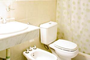a bathroom with a white toilet and a sink at Brisas del Lago Apartamentos in Colón