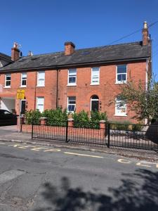 a large red brick building with a black fence at 14 Helena House One Bedroom Apartment in Reading +4 photos