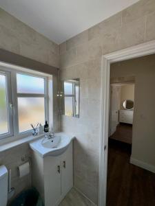 a white bathroom with a sink and a mirror at Enyo House Brentford London in Brentford +20 photos