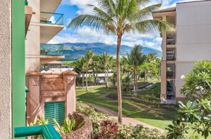 a view from the balcony of a building with a palm tree at Honua Kai Hokulani 214 in Lahaina