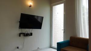 TV de pantalla plana colgada en una pared junto a una ventana en SK Luxury Apartments, en Wattala