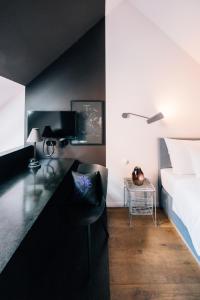 a bedroom with a bed and a desk with a chair at Libertine Lindenberg in Frankfurt/Main