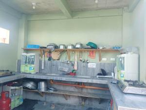a kitchen with a counter top with pots and pans at Villa Monica Hotel in Balatero