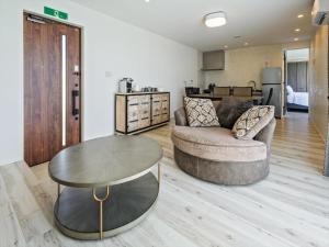 a living room with a couch and a table at abundance okinawa & Kourijima Sauna resort in Kouri