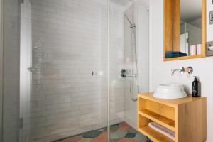 a bathroom with a glass shower with a sink at Libertine Lindenberg in Frankfurt/Main