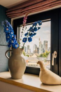 a vase on a window sill next to a vase with flowers at Libertine Lindenberg in Frankfurt/Main