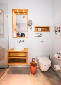 a bathroom with a toilet and a sink and a mirror at Libertine Lindenberg in Frankfurt/Main