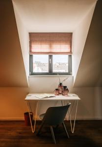 a desk in a room with a window and a chair at Libertine Lindenberg in Frankfurt/Main