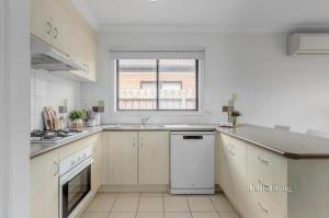 a kitchen with white appliances and a window at The Lakes Homestead - Shared House in Mill Park
