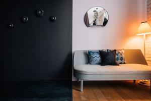 a living room with a couch and a mirror at Libertine Lindenberg in Frankfurt/Main