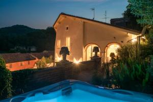 a villa with a swimming pool in front of a building at Ai Leoni Ruggenti Dimora della Storia e del Relax in Monferrato in Ottiglio