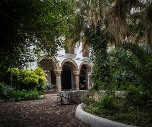 a building with a palm tree in front of it at Palacio de los Angulo casa histórica en el centro de Córdoba in Córdoba