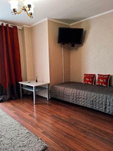 una camera da letto con un letto e una TV a parete di Spacious apartment with balcony a Kremenčuk Altre 7 foto