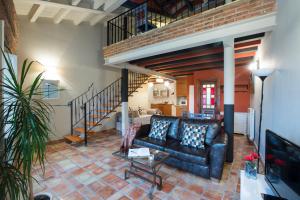 a living room with a couch and a staircase at Apartamentos Señorio de Haro in Haro